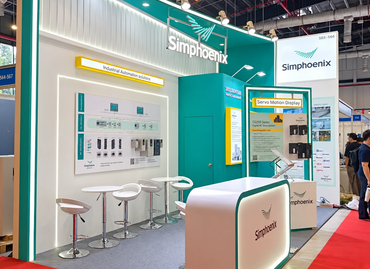 Turquoise and white Simphoenix booth with industrial control displays, stools and a reception counter